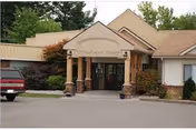 Willowbrook Manor entrance with a covered front porch and shrubs.