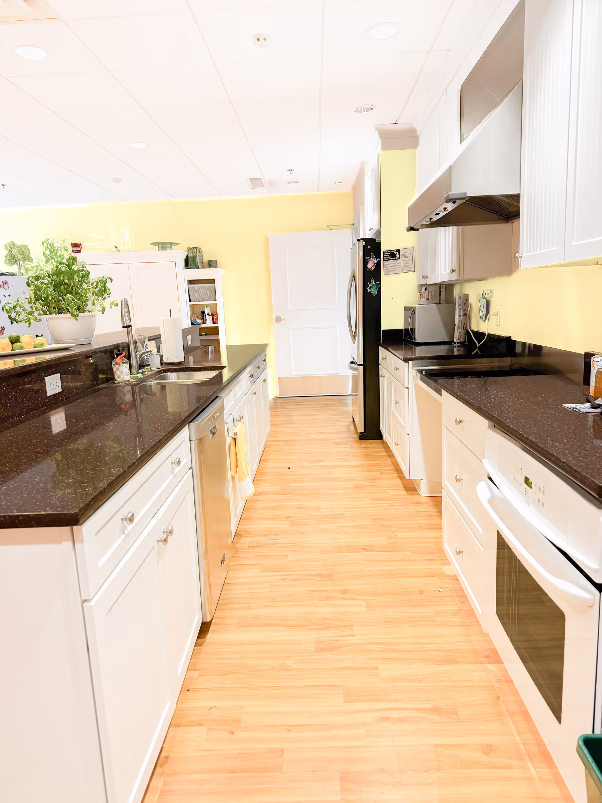 Bright, modern kitchen in Blissful Cottage with white cabinets, dark countertops, and stainless appliances.