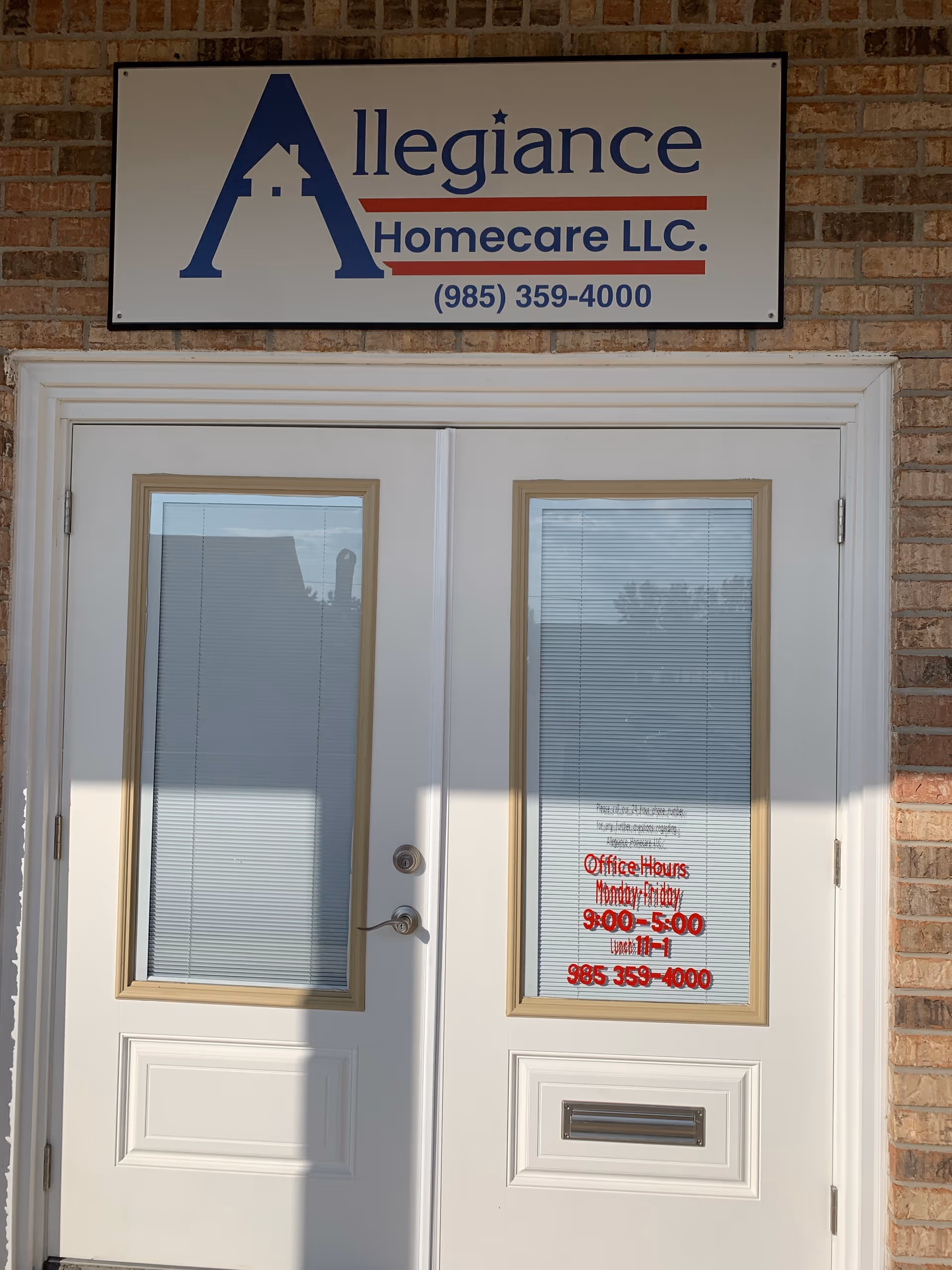 Front entrance of Allegiance Homecare LLC with double doors, brick exterior, and sign.