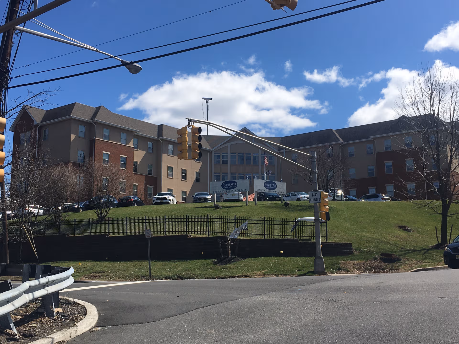 Exterior view of Roosevelt Care Centers building complex with cars parked along the front lawn.