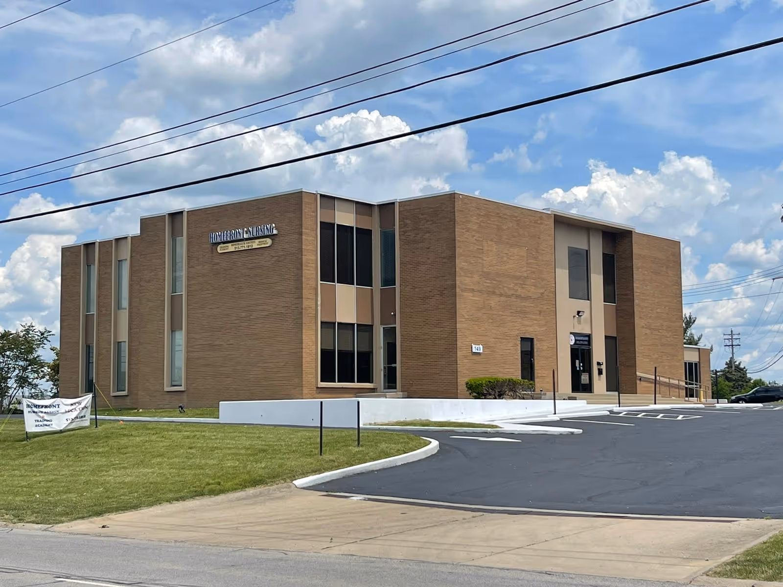 Exterior view of a brick senior living facility with entrance and parking.