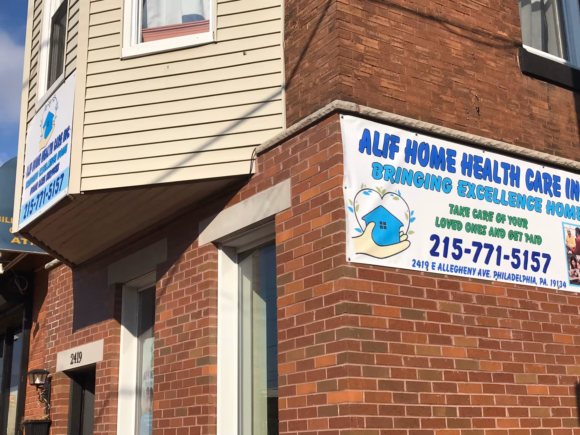Brick building corner with a large banner Advertising Alif Home Health Care Inc.
