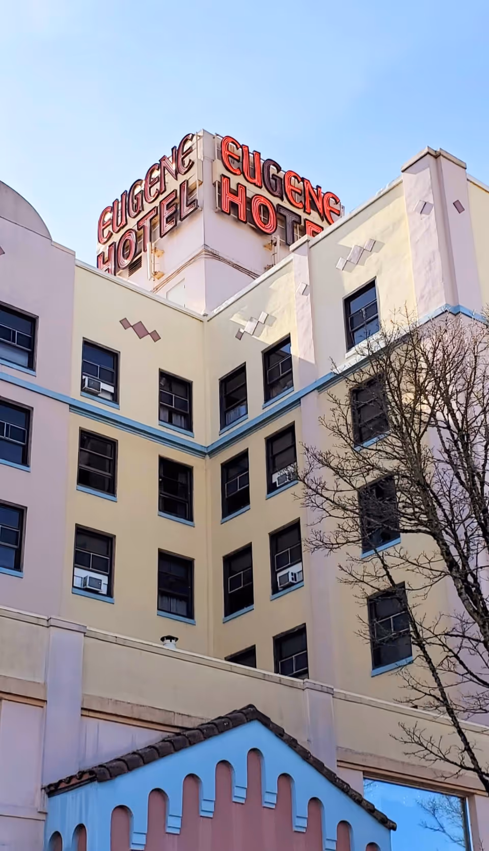 Exterior view of a multi-story retirement facility with a red Eugene Hotel sign.