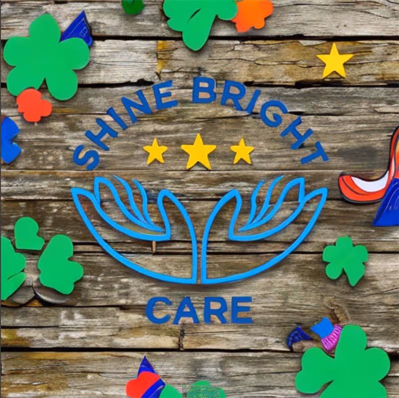 Colorful Shine Bright Care sign with clover shapes on weathered wooden backdrop.