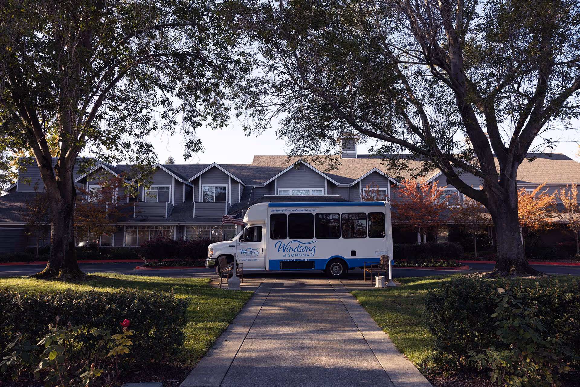 Front view of Windsong of Sonoma Senior Living with a parked shuttle bus.