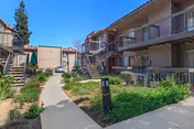 Exterior courtyard of a senior living facility with walkways, stairs, and multi-level balconies.