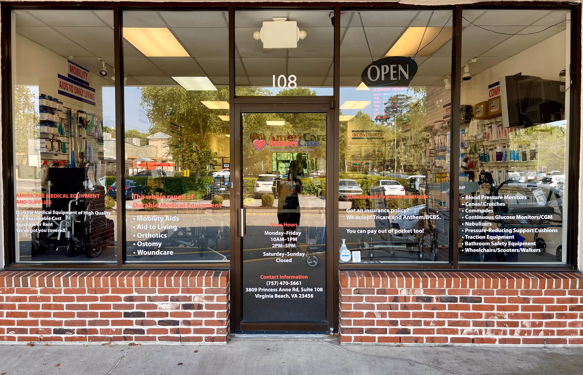Glass storefront of Americare Medical Supplies with an open sign and displayed products.