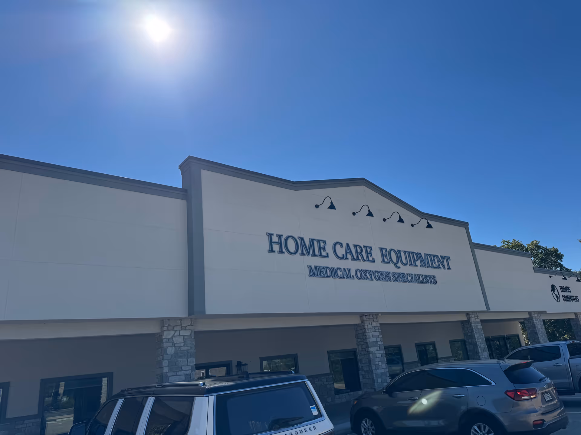 Home Care Equipment storefront with parked cars in front on a sunny day