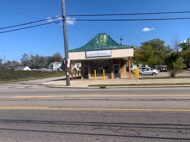 Small storefront-style building with a green gable roof and a Pacific Home Care sign.