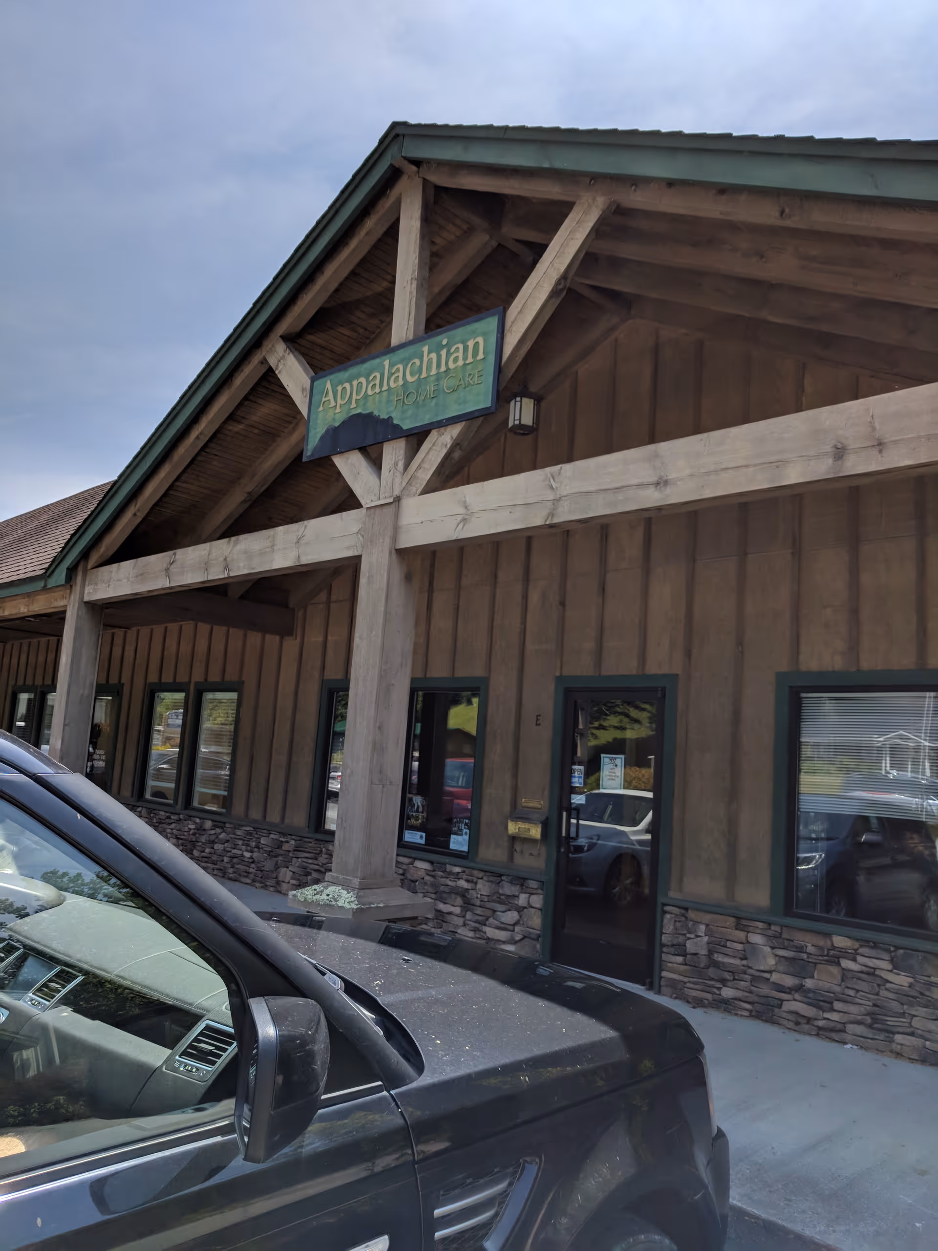 Exterior of Appalachian Home Care facility with sign and parked SUV.