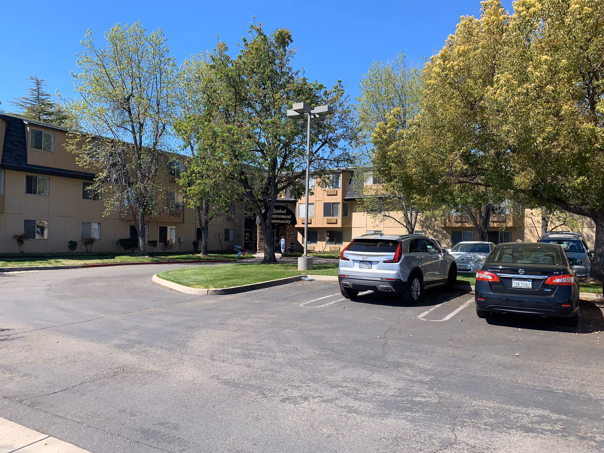 Exterior view of Bethel Retirement Community with parked cars near the entrance.
