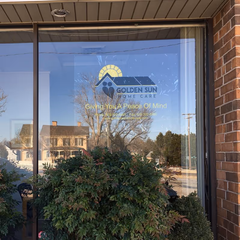 Front glass storefront displaying Golden Sun Home Care LLC logo with surrounding plants