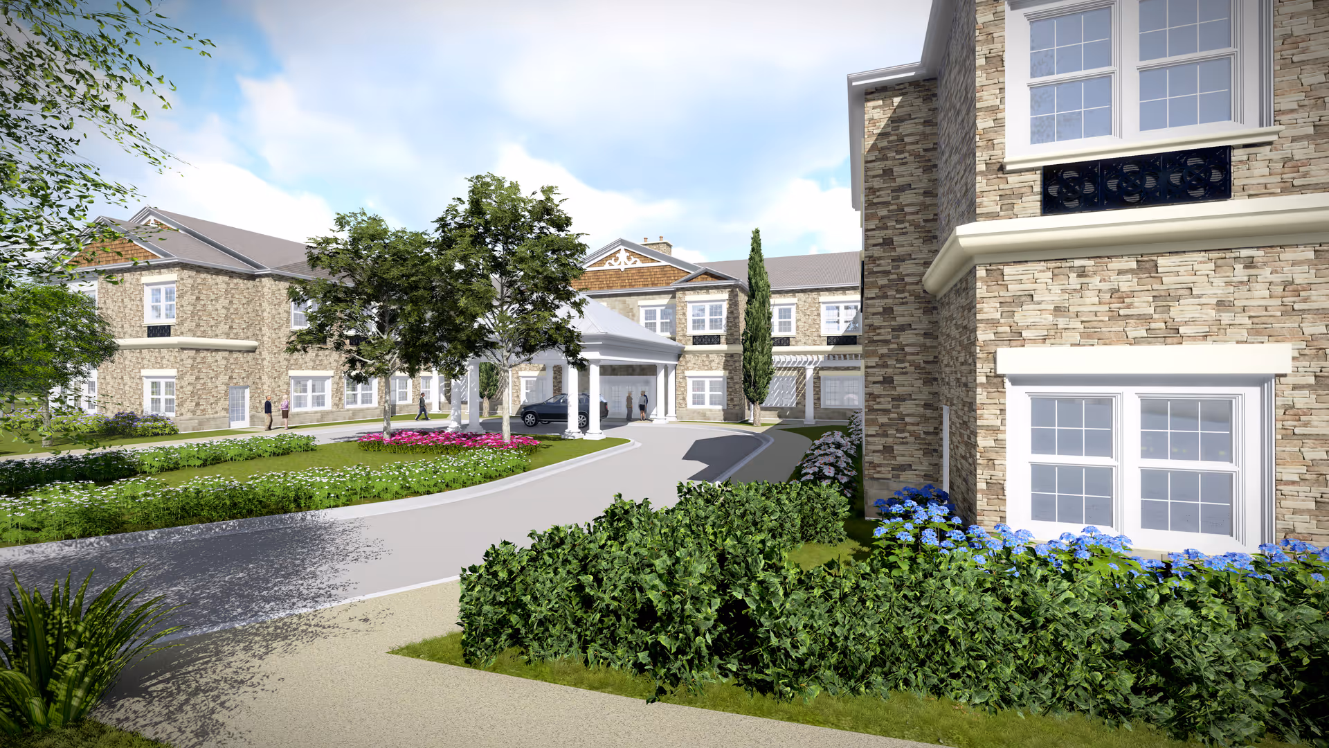 Exterior view of Manorhouse Assisted Living and Memory Care building with stone facade, multiple windows, a covered entrance, landscaped greenery, trees, and flower beds under a partly cloudy sky.