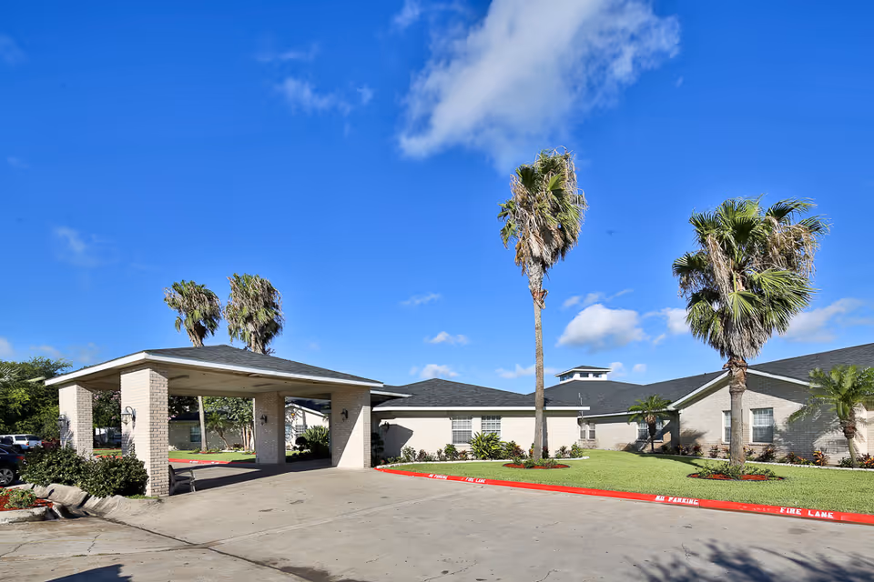 Exterior view of Edinburg Nursing and Rehabilitation Center with palm trees and entrance canopy.