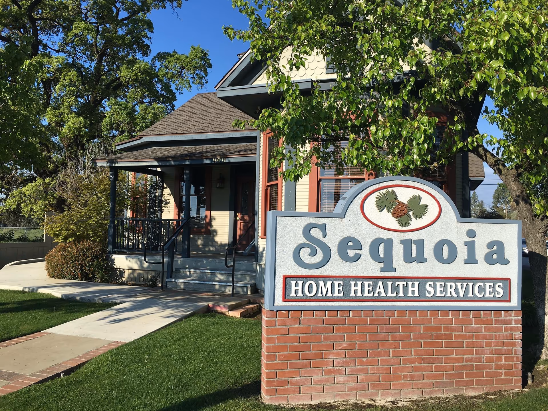 Exterior view of Sequoia Home Health Services building with a large sign and trees.