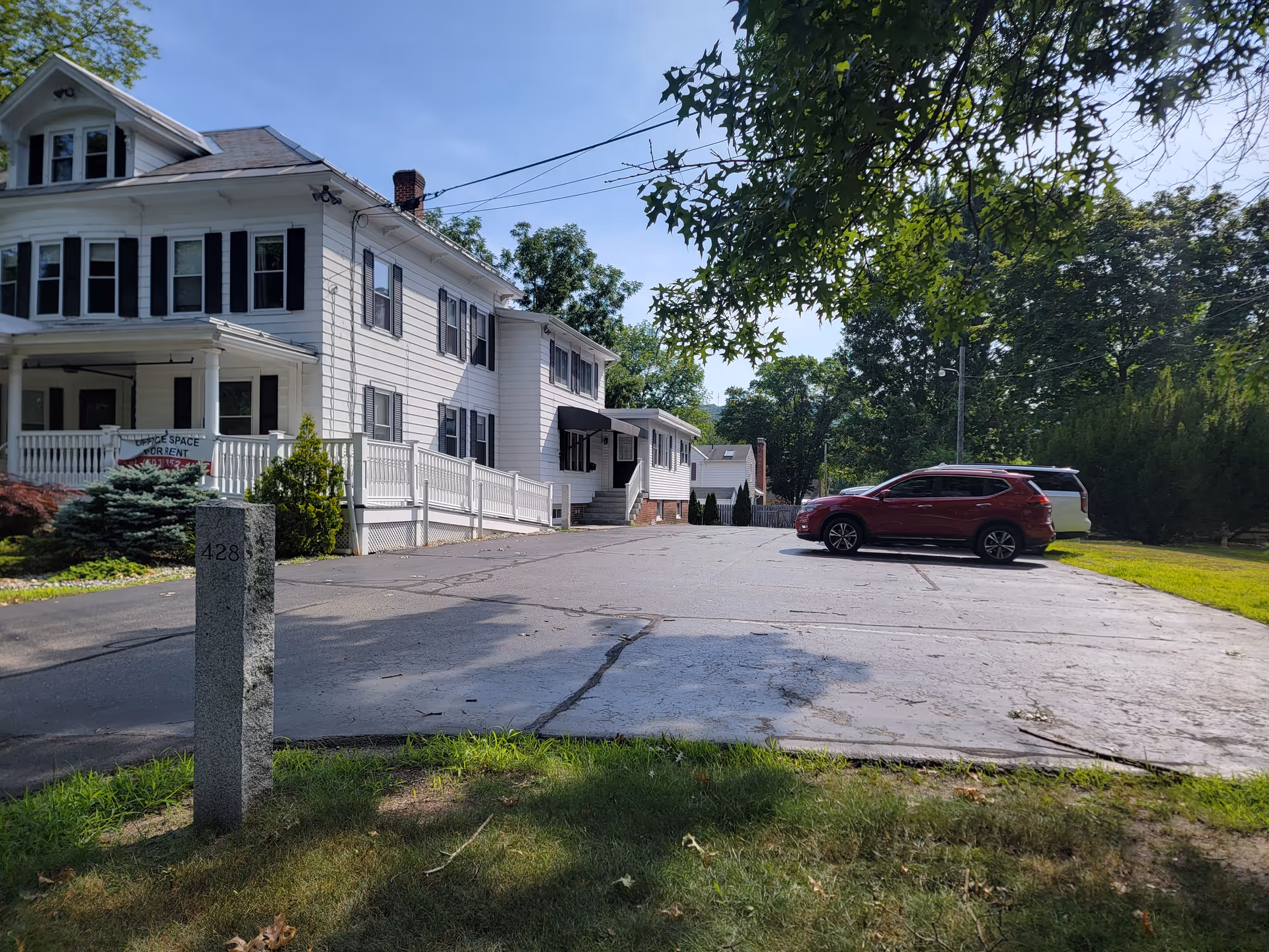 Front view of Custom Helpers Home Health Care LLC, a white two-story facility with parking.
