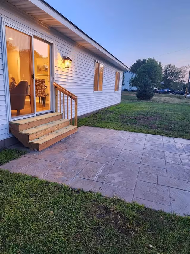 Exterior view of Castillo Custom Care Living LLC: white siding, wooden steps, sliding door, patio.