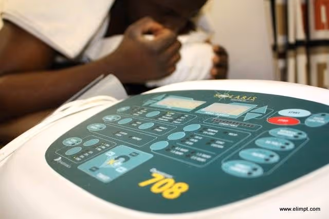 Close-up of a medical device control panel with a blurred person in the background.