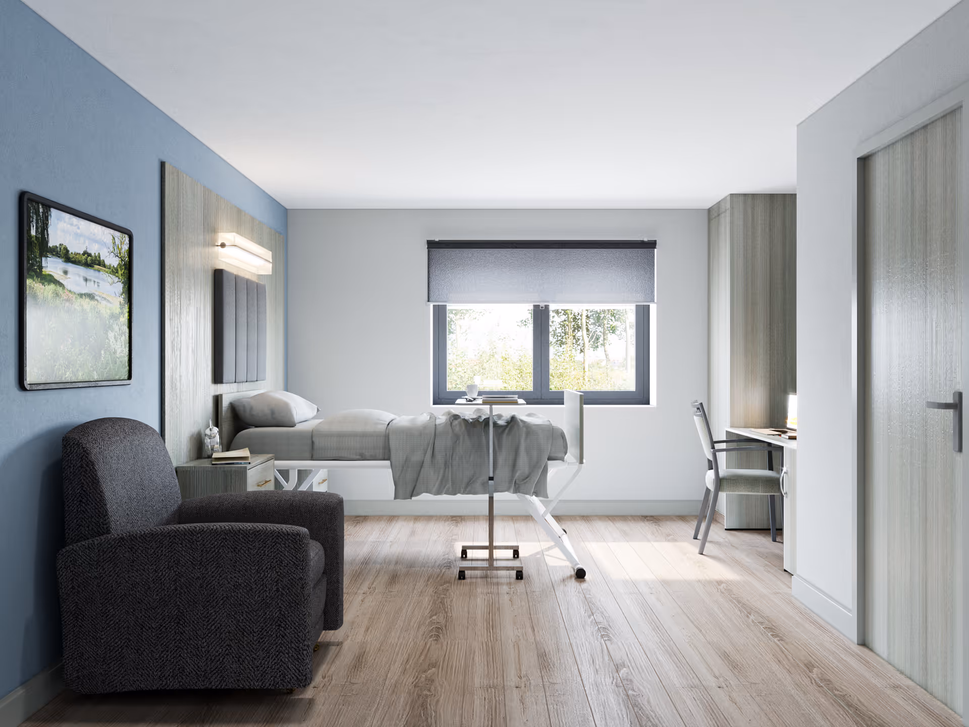 A modern, furnished patient room with a bed, chair, desk, and window.