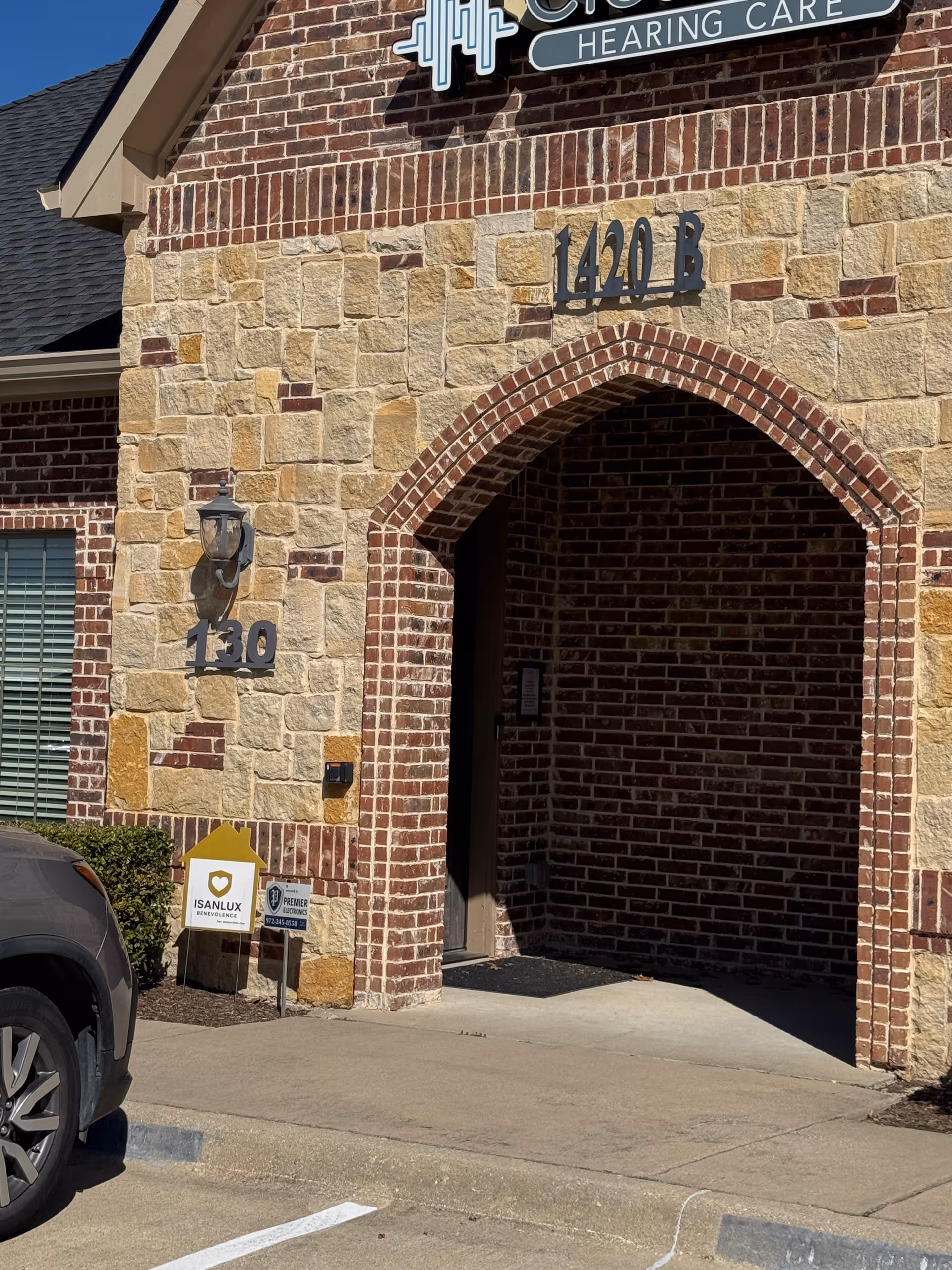 Stone and brick senior living facility entrance with arched doorway.
