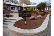 Exterior view of Apple Rehab Rocky Hill entrance with curved stone planter.