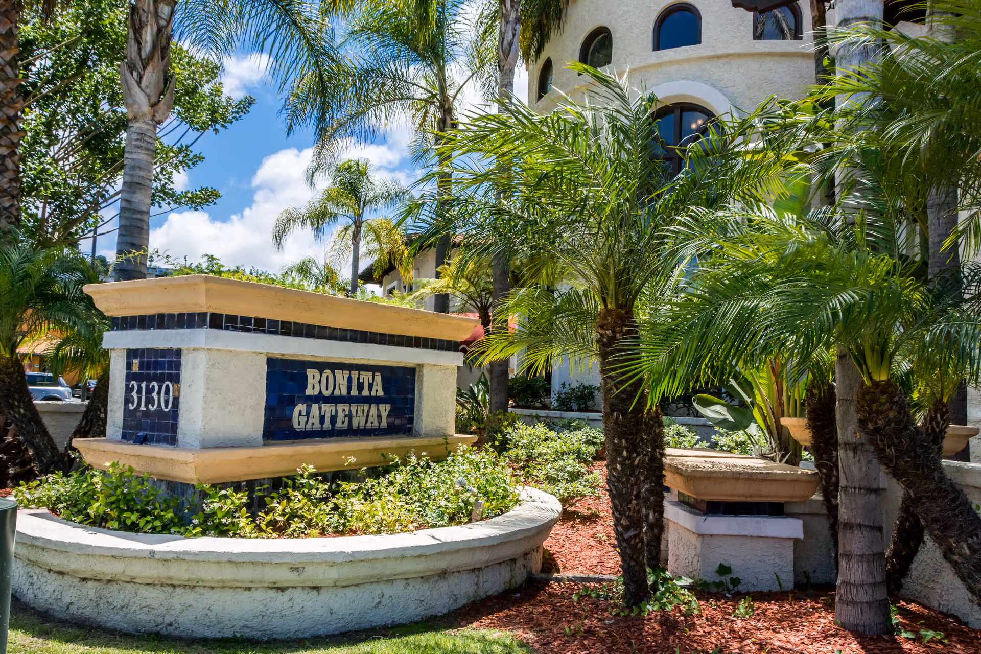 Exterior view of a senior living facility sign reading Bonita Gateway among palm trees.