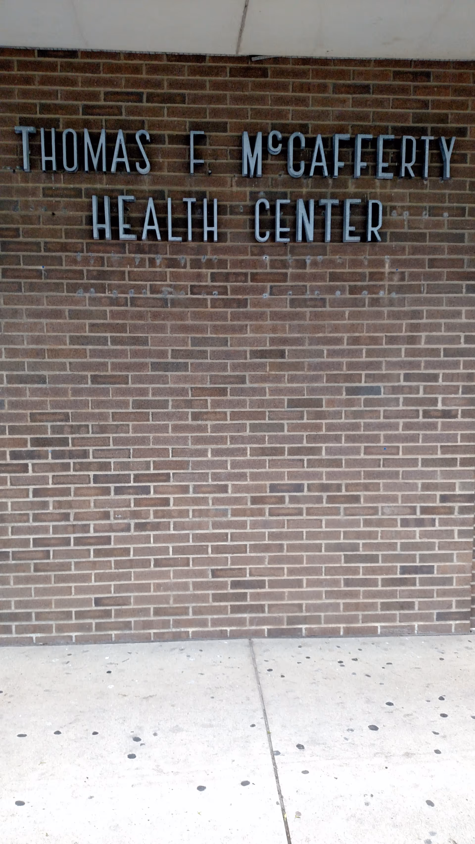 Brick wall with metal letters reading Thomas F. McCafferty Health Center.