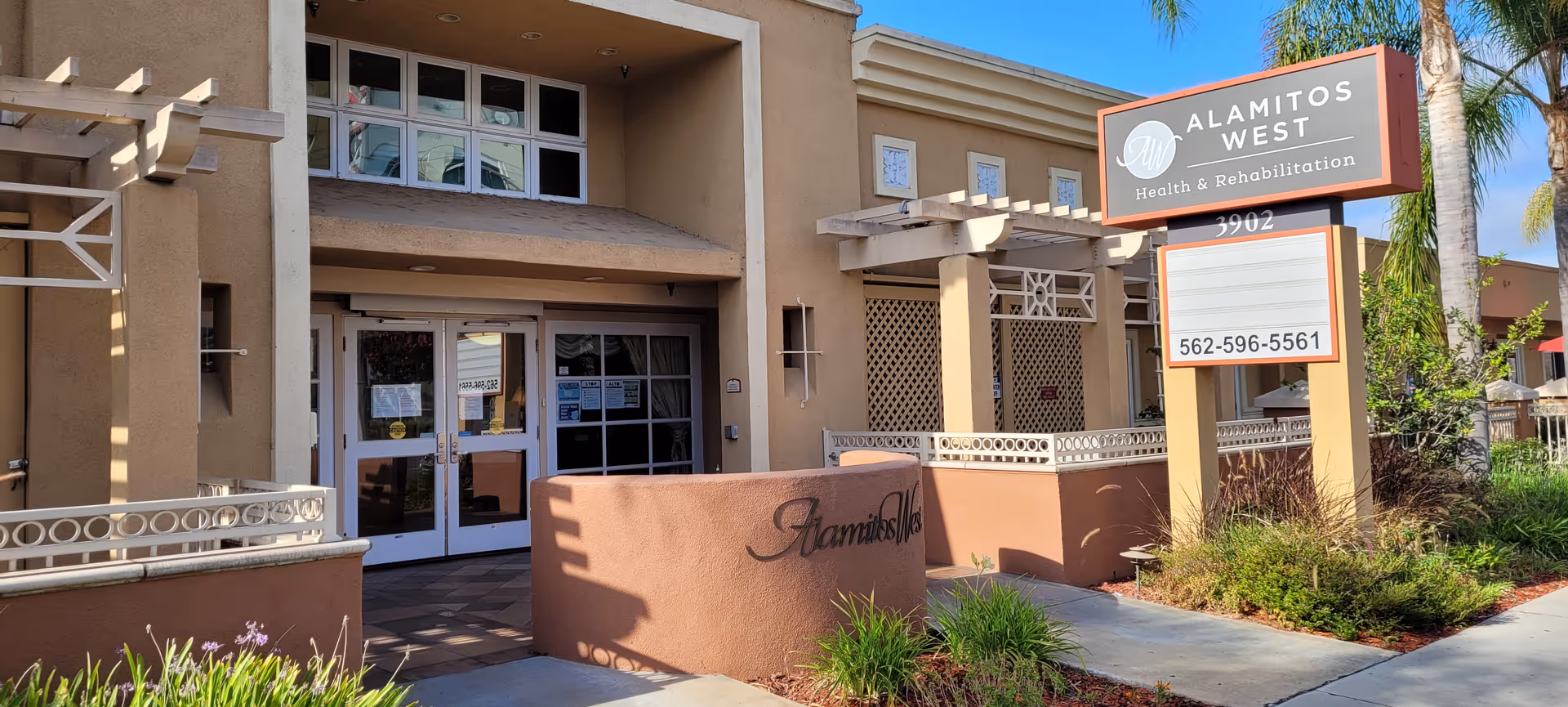 Exterior view of Alamitos West Health & Rehabilitation facility entrance with signage.