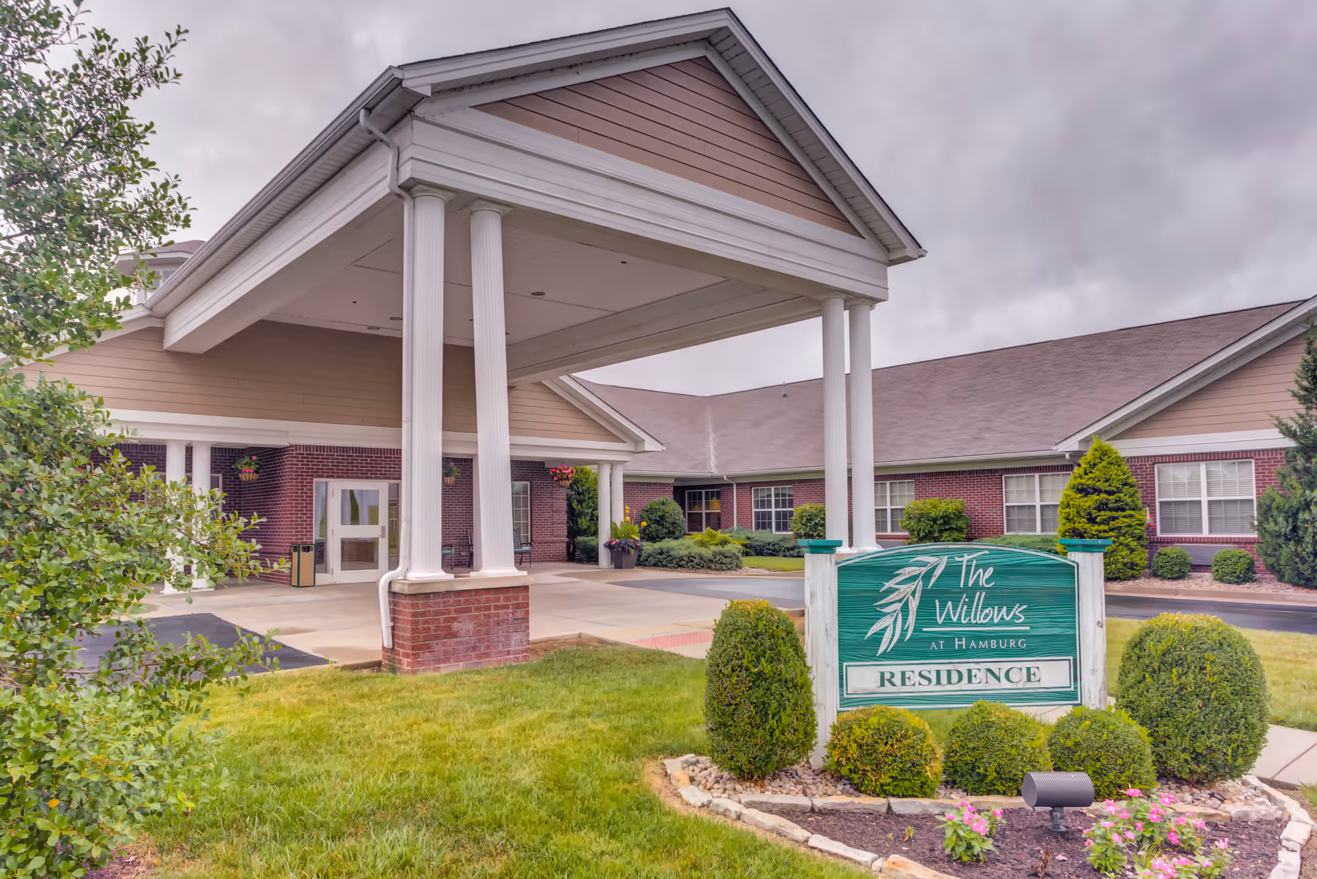Front entrance of The Willows at Hamburg with porte-cochere and landscaped sign.