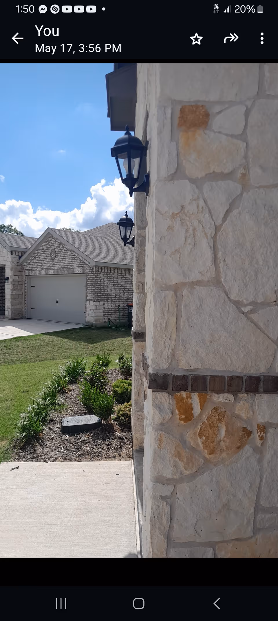 Exterior view of Ginger Avenue Home Care building with stone wall, lamps, sidewalk, and landscaping.