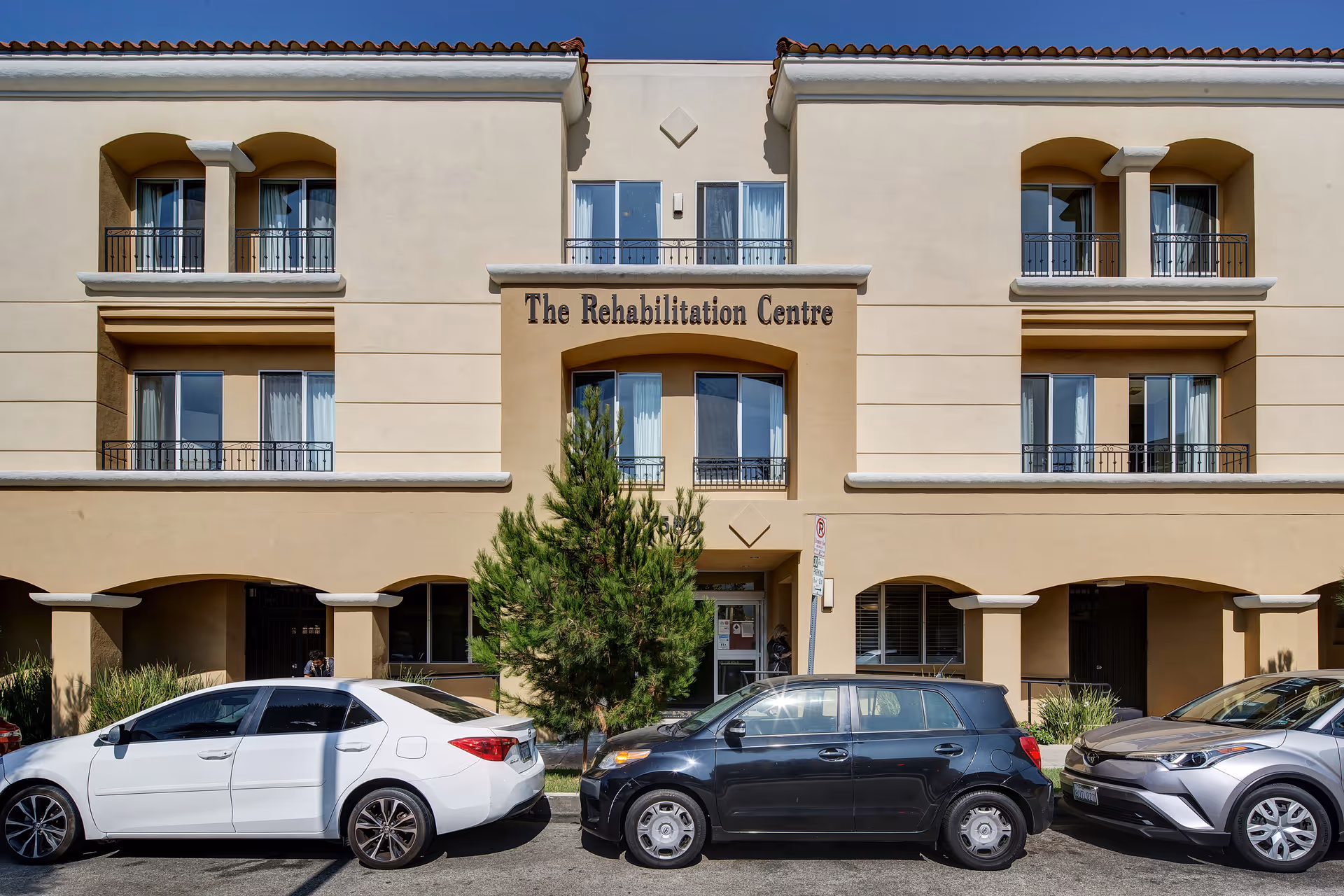 Exterior view of The Rehabilitation Centre Beverly Hills with parked cars in front.