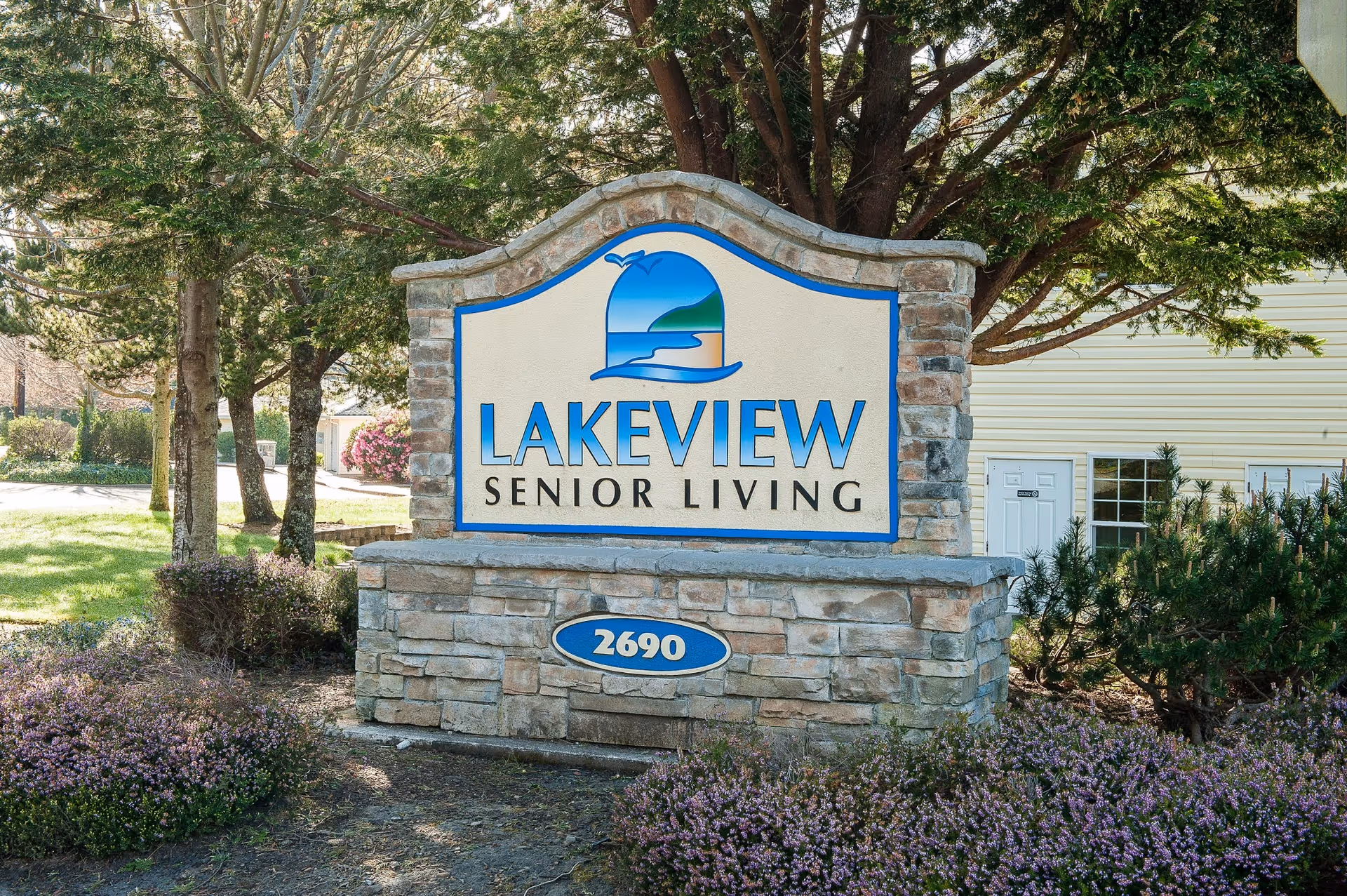 Stone entrance sign reading Lakeview Senior Living with the address 2690, surrounded by landscaping and a building in the background.