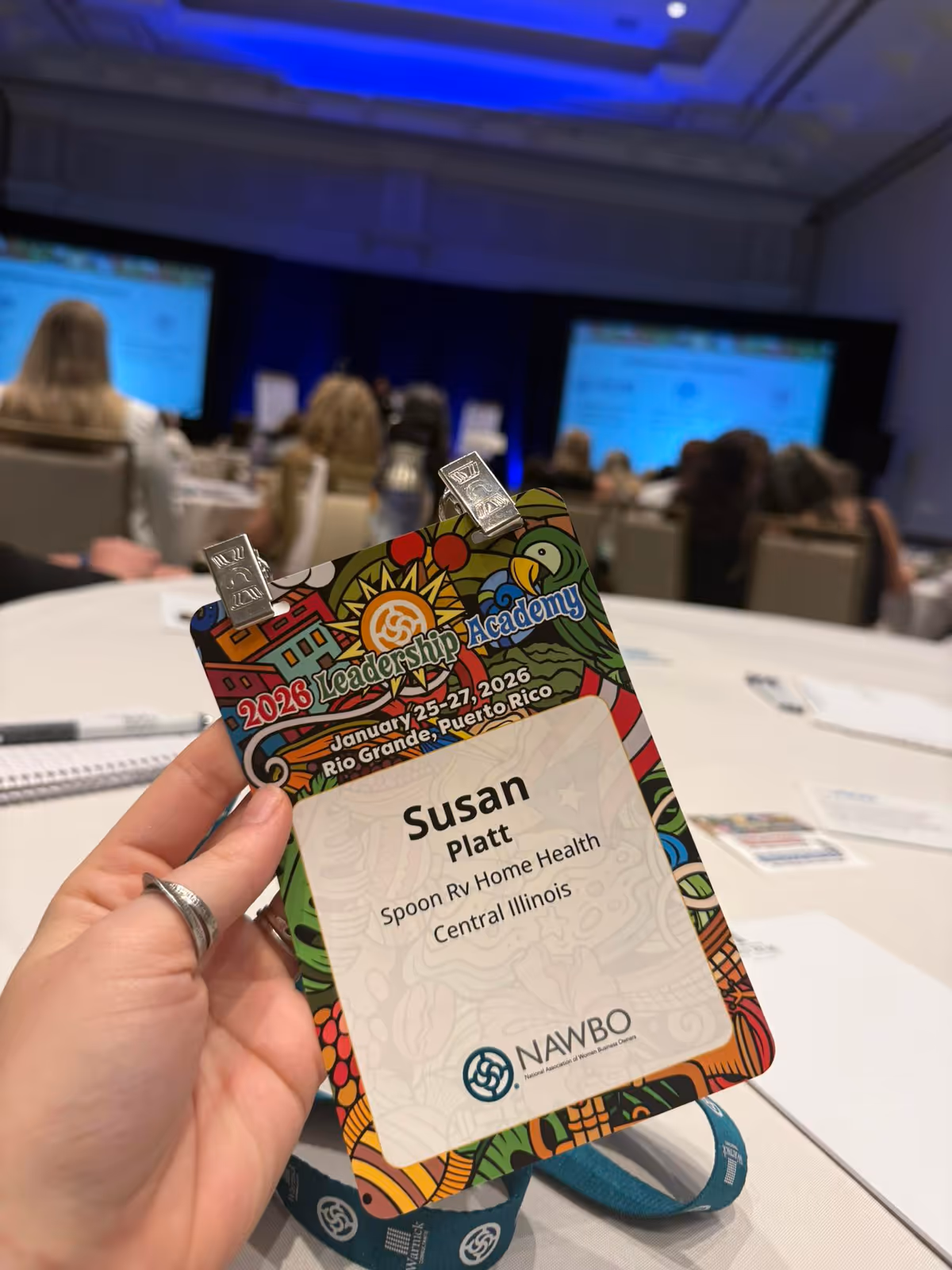 Close-up badge reads Susan Platt for Spoon River Home Health Services at an indoor conference.