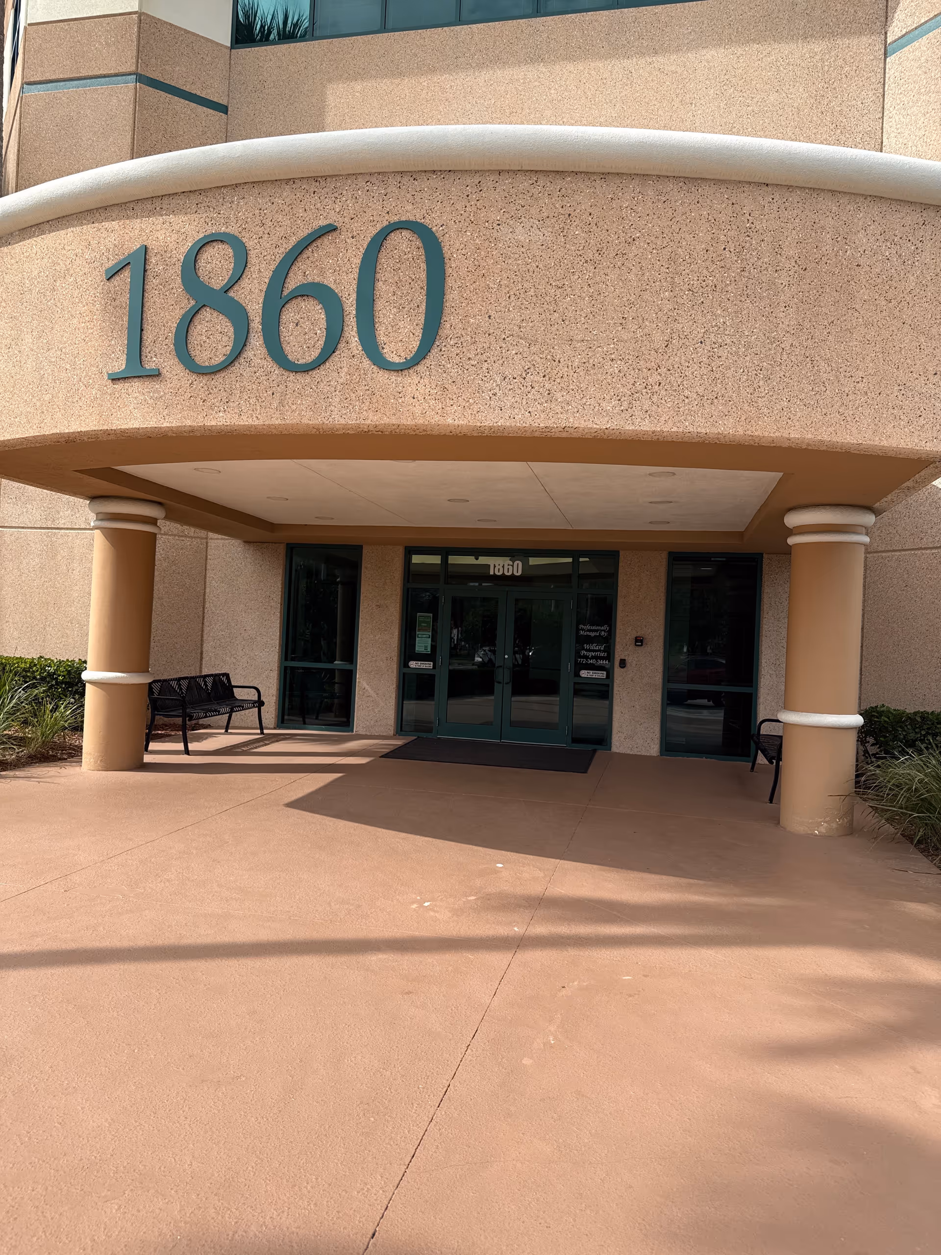 Front entrance of Aqua Home Care with large 1860 numbers and benches outside