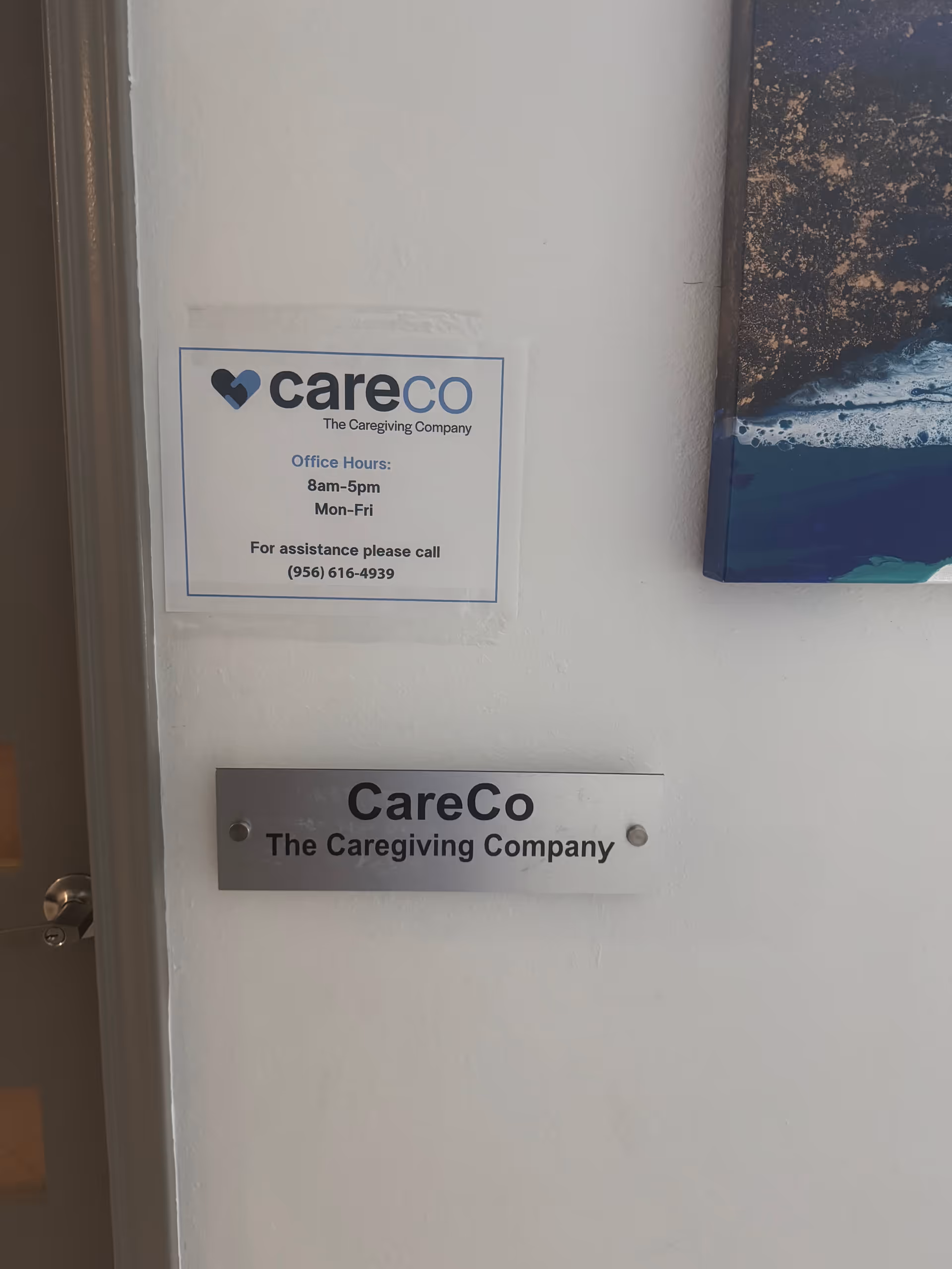 Interior wall with CareCo signage and a metal plaque beside a doorway.