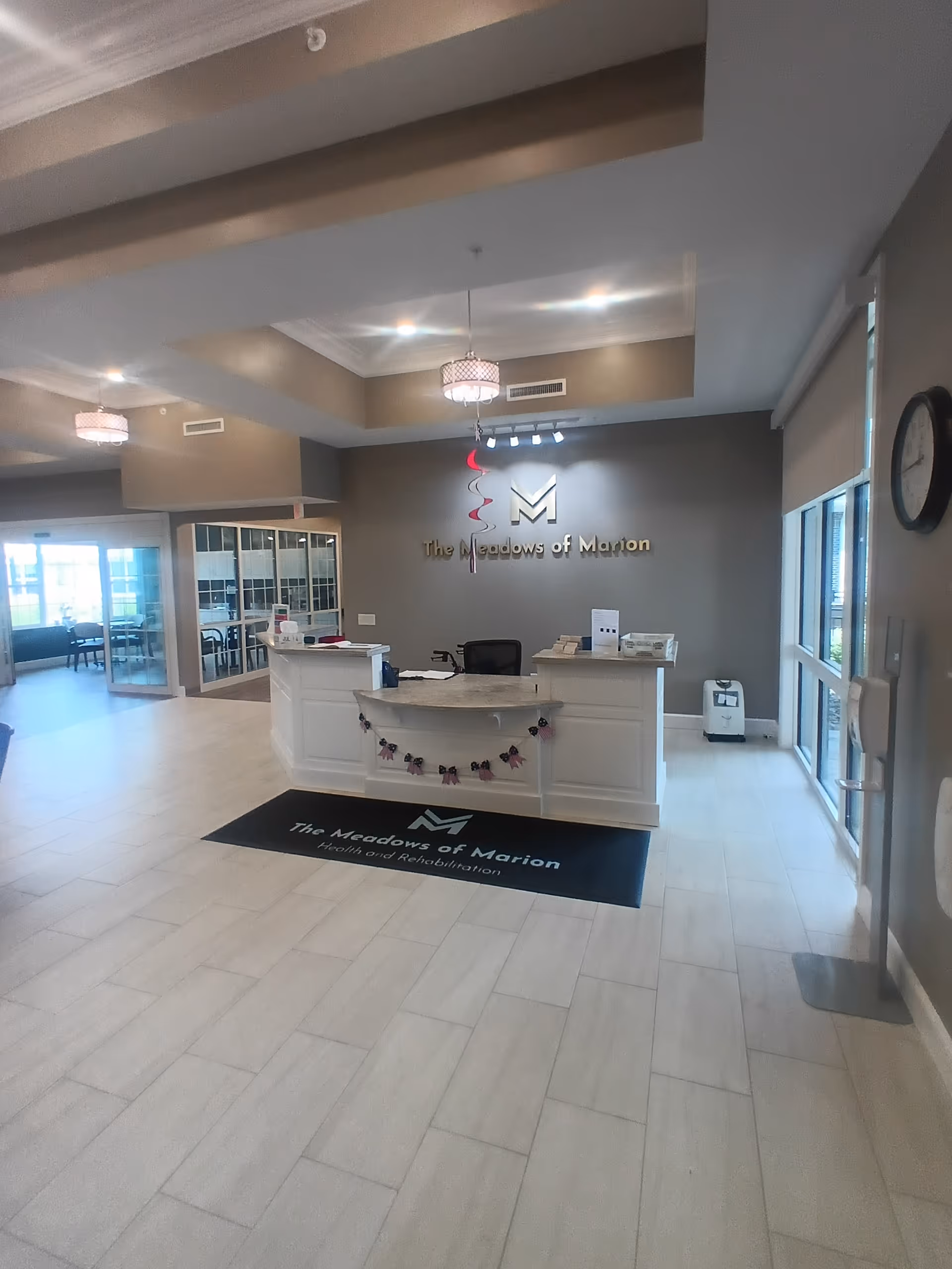 Reception desk in a bright lobby featuring The Meadows of Marion branding.
