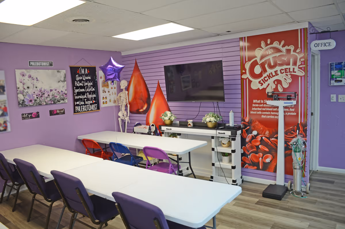 Purple-walled activity room with tables, chairs, a wall-mounted TV, decor, and a skeleton model.