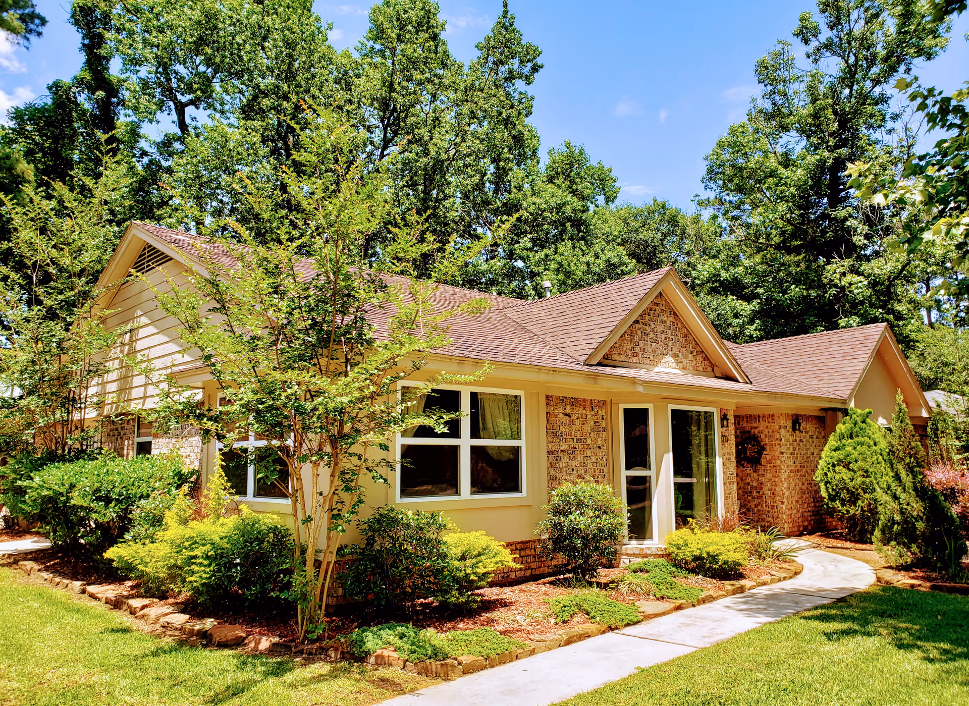 Single-story brick facility with beige siding, large windows, and a curved walkway.
