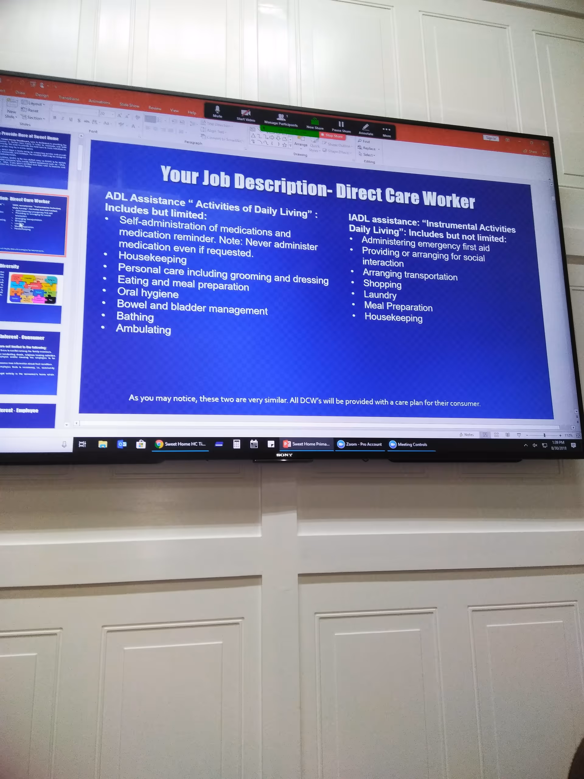 Large screen displays a slide titled 'Your Job Description- Direct Care Worker' in a training room.