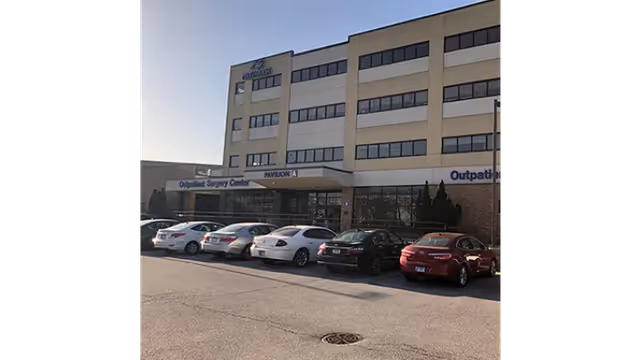 Exterior view of Methodist Hospitals Rehab Center building with cars in parking lot.
