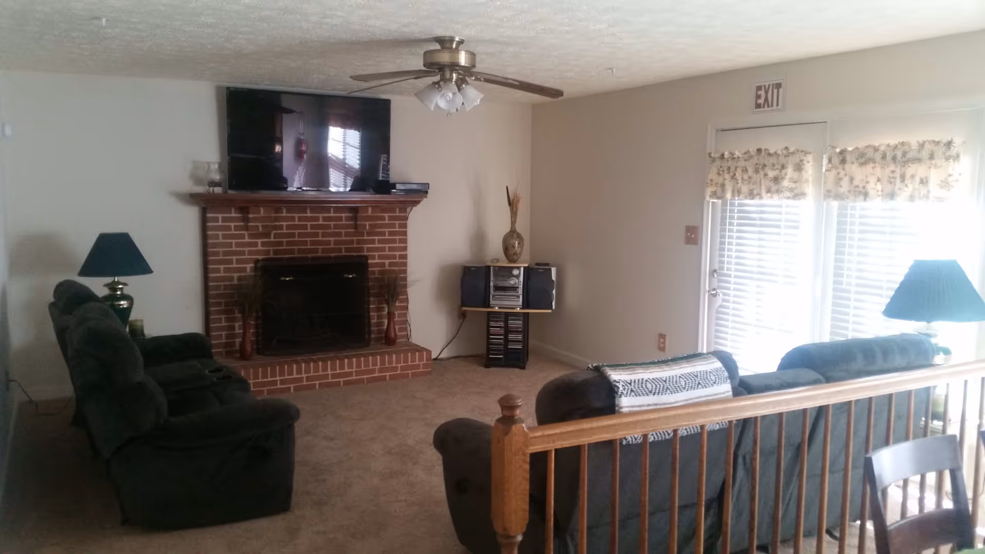 Cozy living room with brick fireplace, TV, and multiple seating areas.