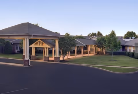 Exterior view of a single-story assisted living building with a covered entrance.