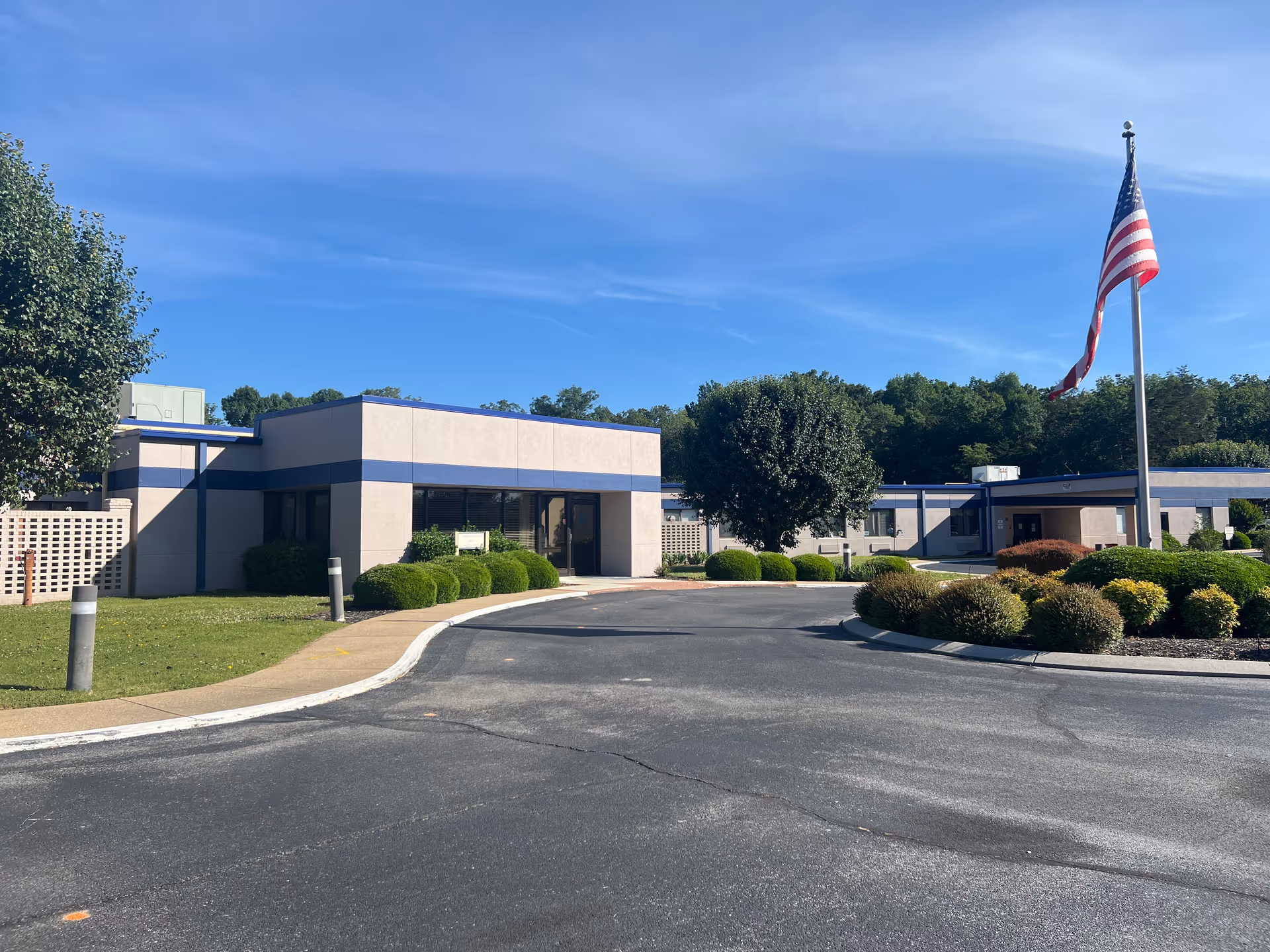 Exterior view of Nhc Healthcare Ft Oglethorpe, with flagpole and entrance driveway