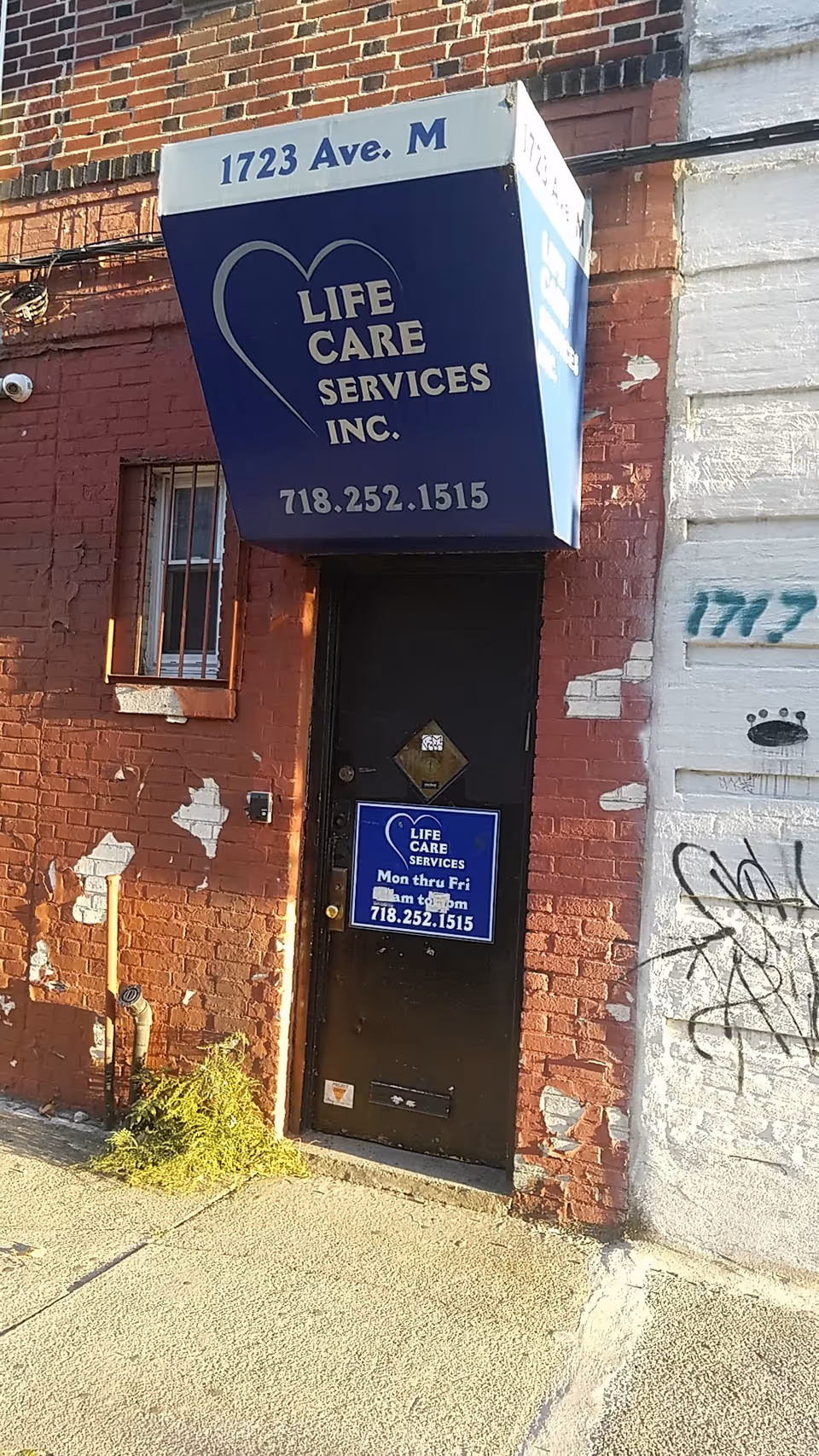 Exterior brick building with Life Care Services sign and dark door.