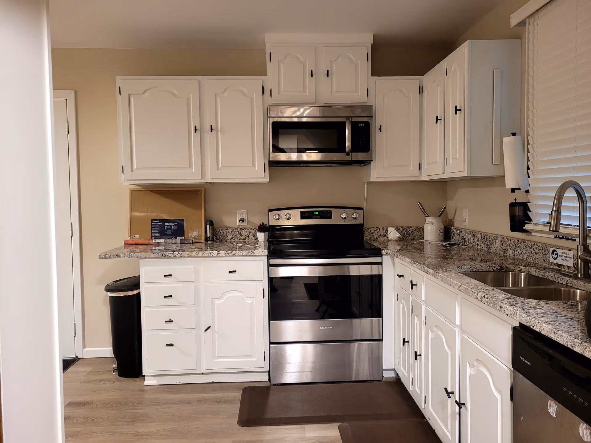 Senior living facility kitchen with white cabinets, granite countertops, and stainless steel appliances.