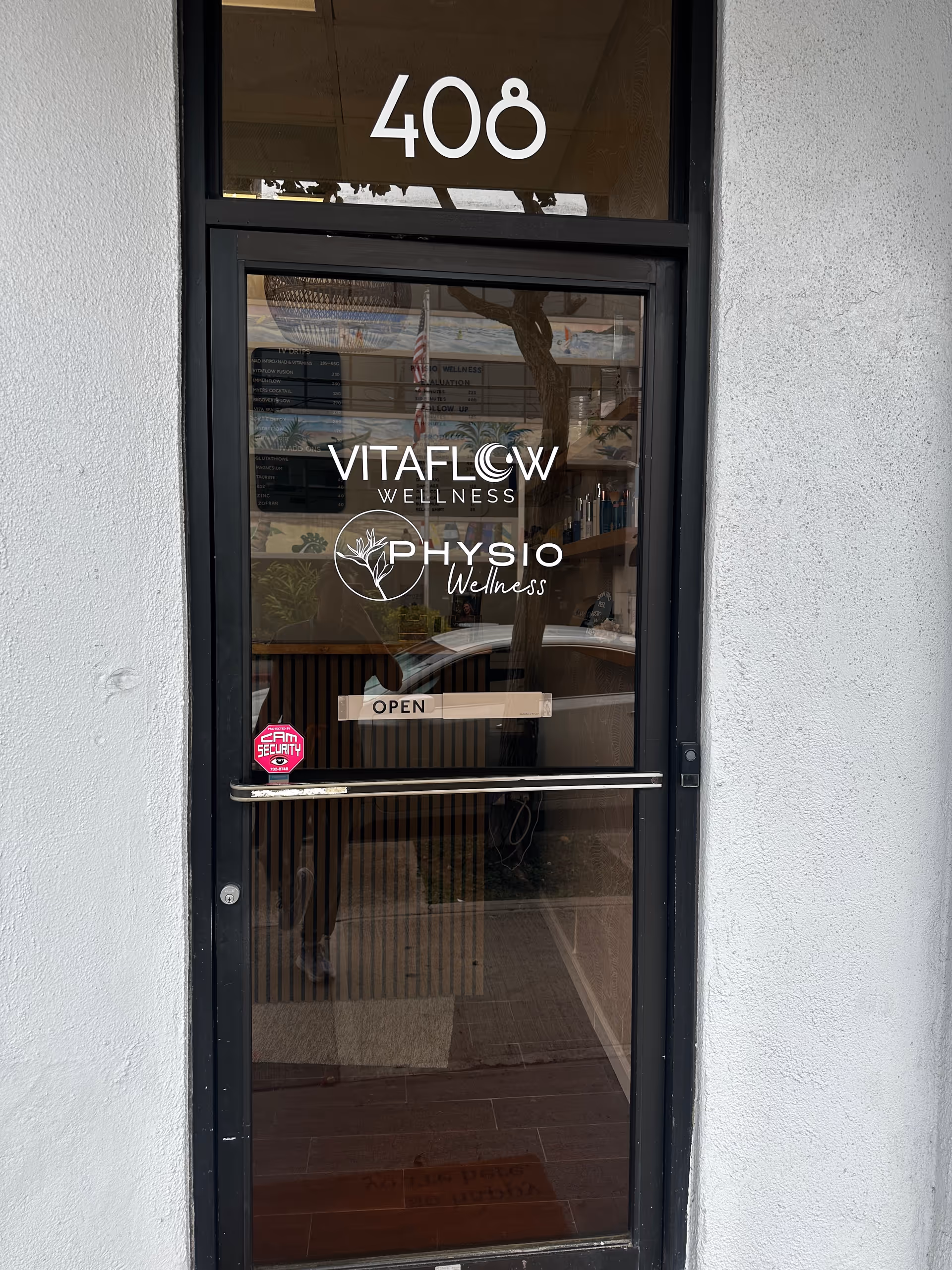 Front glass door of facility with 408, VitaFlow Wellness and Physio Wellness logos.