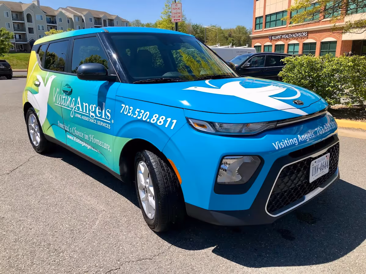 A blue Visiting Angels van with branding is parked outside a Leesburg building.