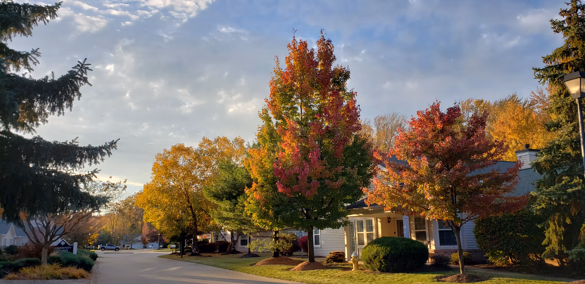 Exterior view of Sprenger Health Care Towne Center Community Campus with autumn trees along a street.