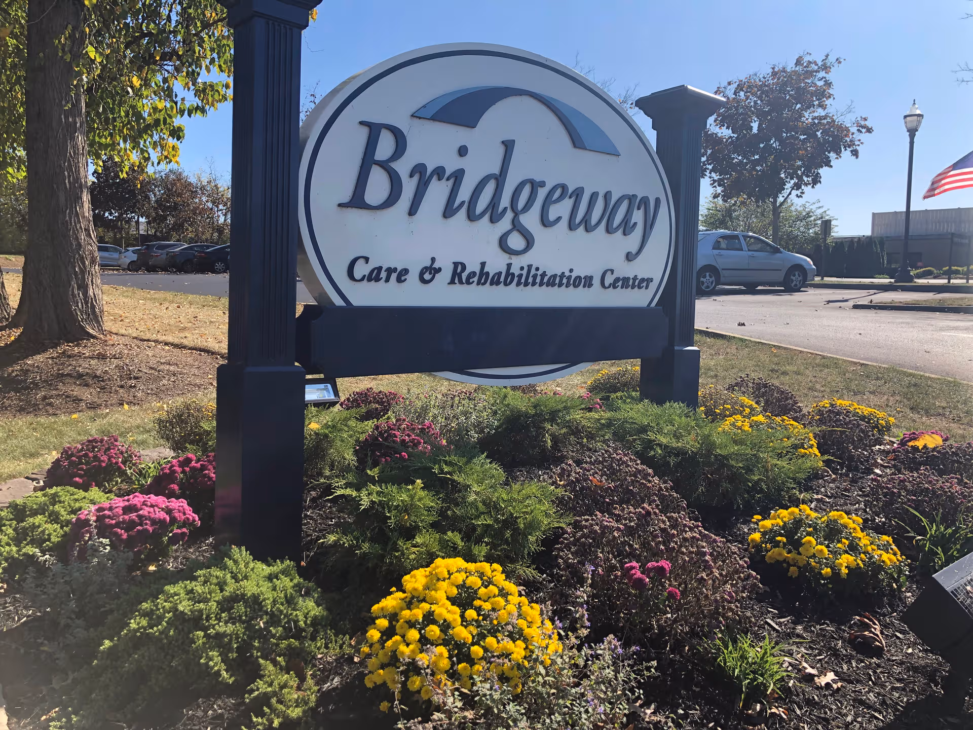 Bridgeway Care & Rehabilitation Center sign with colorful flowers in landscaping.