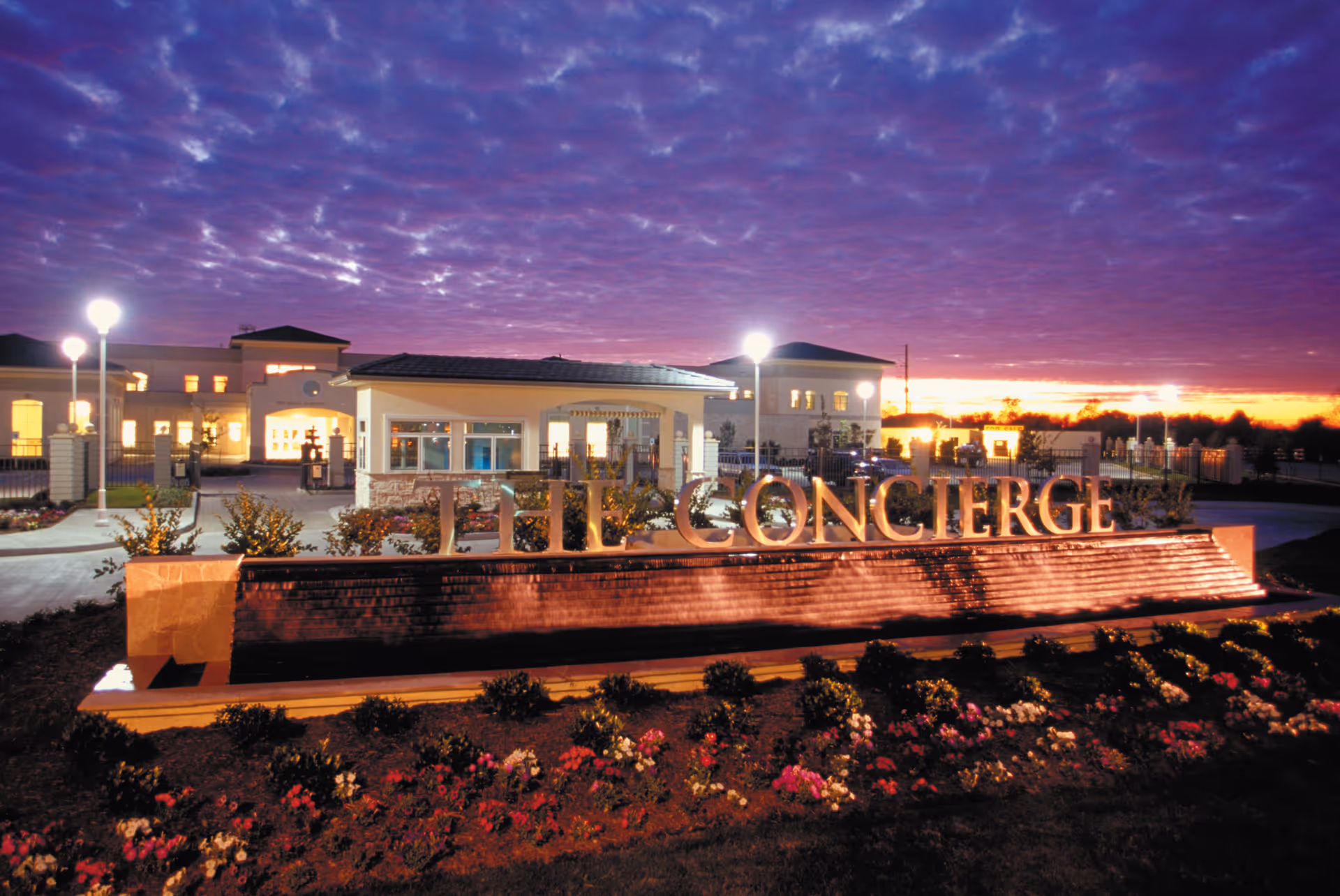 Senior living facility exterior with illuminated THE CONCIERGE sign and landscaped front.